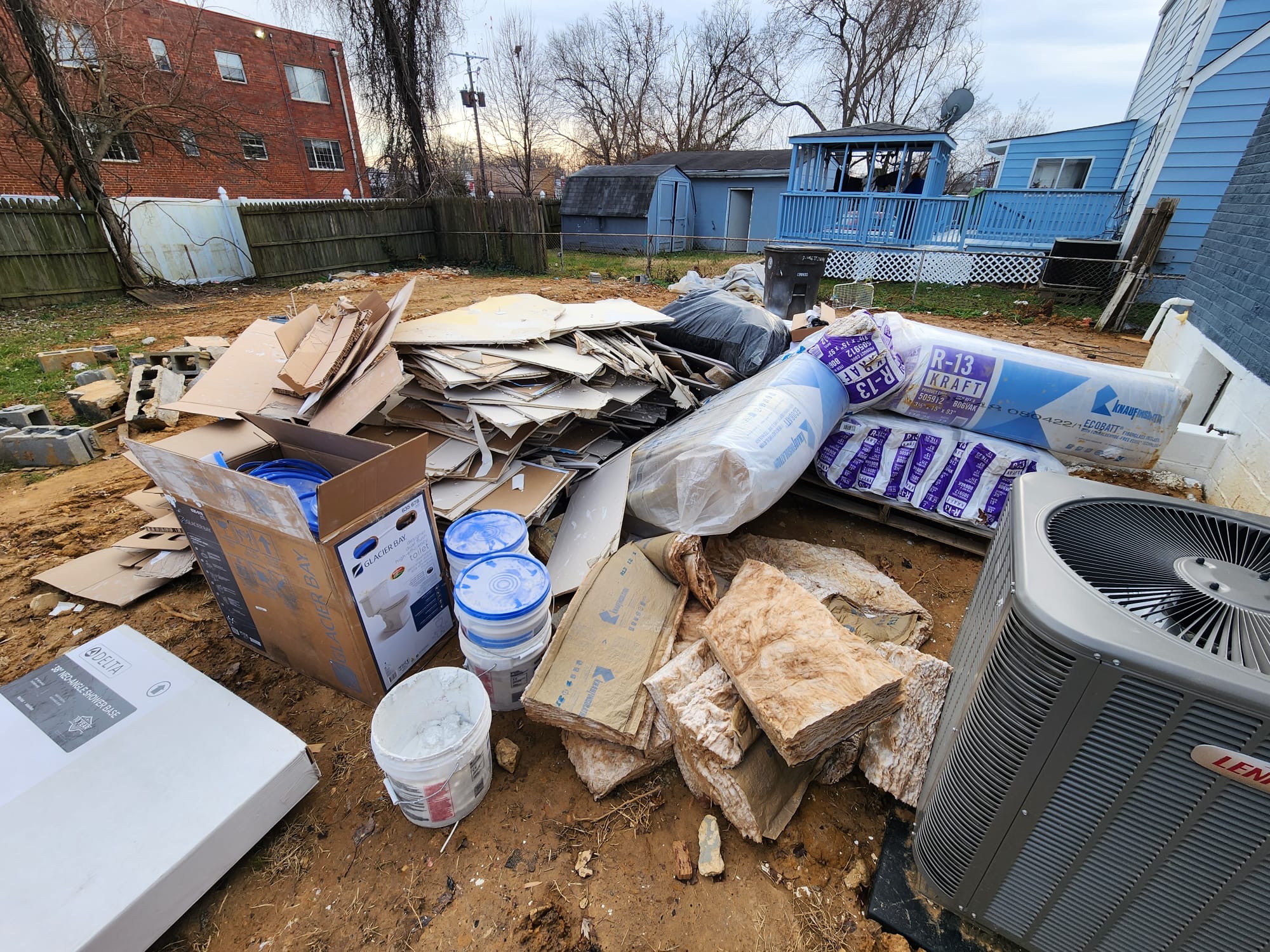 Drywall and insulation piled in a backyard after a renovation