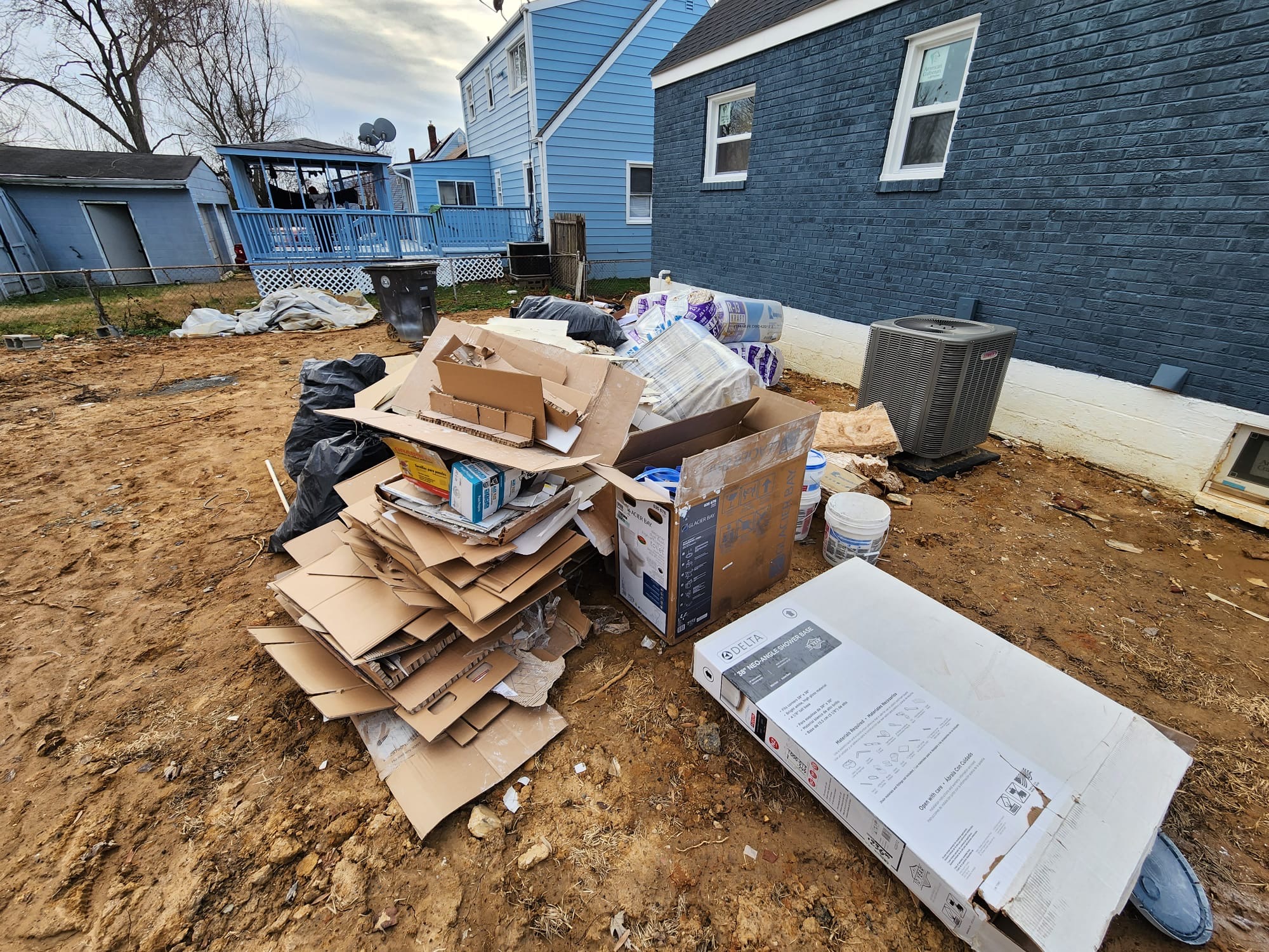 Northern Virginia backyard with insulation, drywall and fixture boxes staged for removal