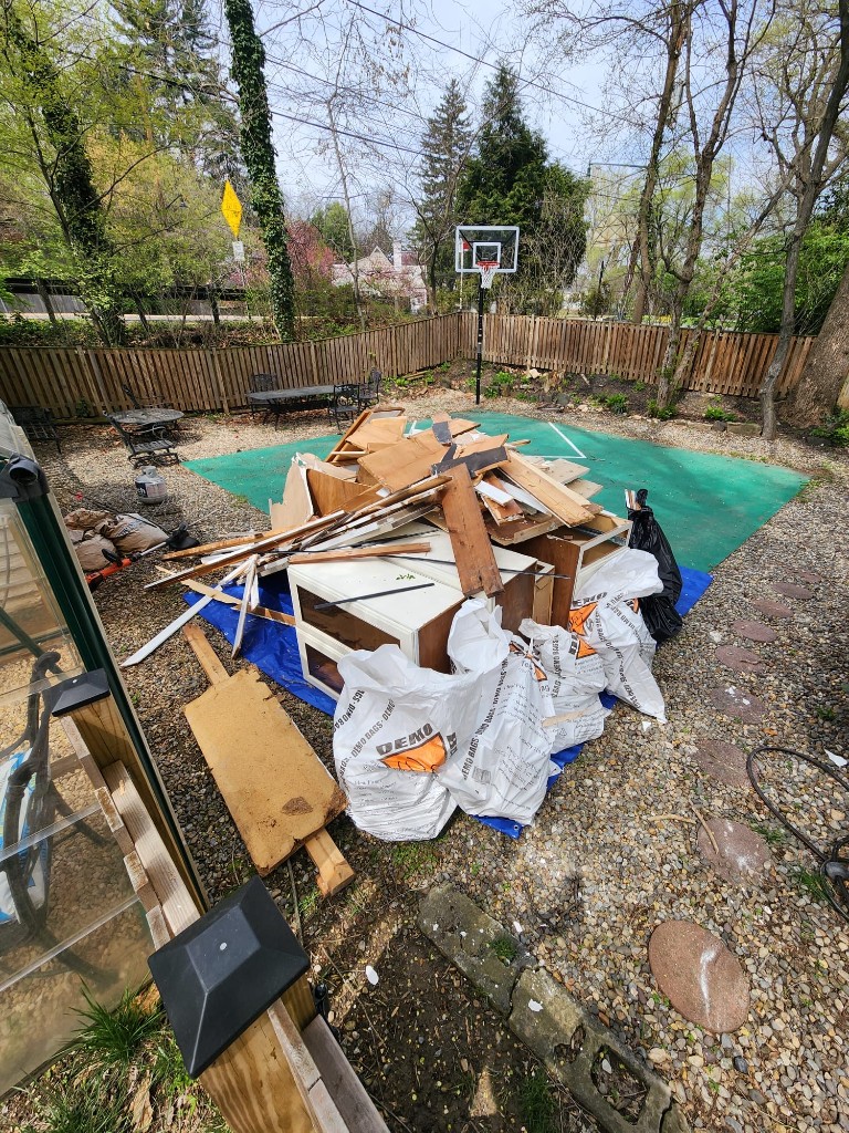 Backyard pile of demo bags, cabinets and scrap lumber
